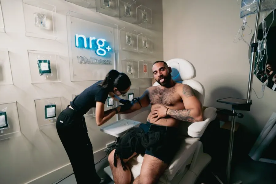 A nurse administering an IV drip in the NRG Haus IV therapy chair